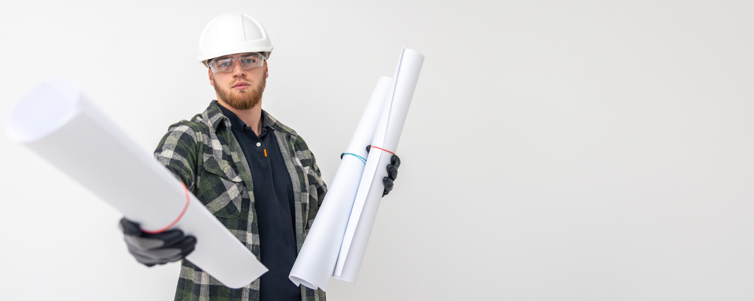 Robotnik trzymający w ręku plany budowy