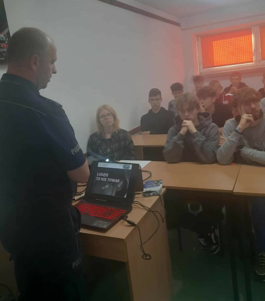 Grupa osób siedząca w sali