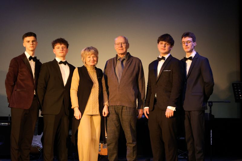 Pani Agnieszka Dzieniakowska, prawnuczka Jana Kostaneckiego, wraz z mężem, Panem Maciejem Dzieniakowskim, oraz uczniami wcielającymi się w role Patronów, pozują na scenie do zdjęcia tuż po części oficjalnej uroczystości.