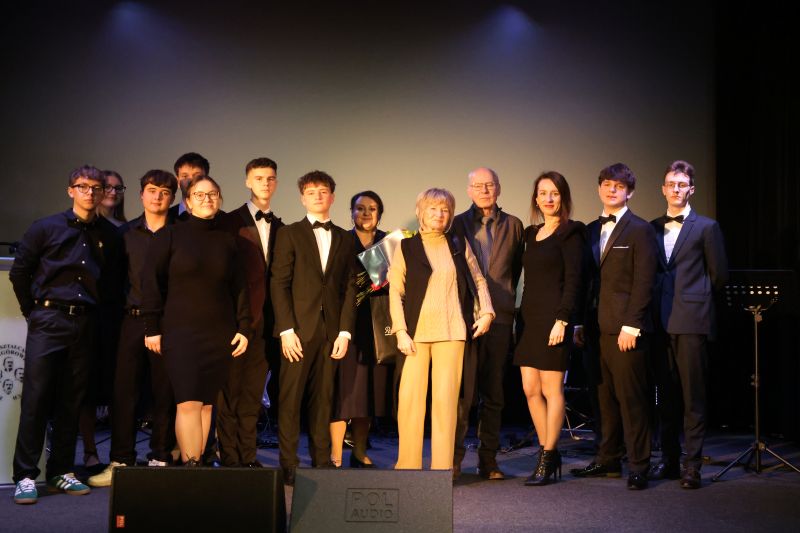 Dyrektor ZSOiZ, Pani Małgorzata Iwanicka, Państwo Agnieszka i Maciej Dzieniakowscy, Pani Katarzyna Maciocha, zespół Kostanecki Band oraz uczniowie wcielający się w role Patronów pozują do wspólnego zdjęcia na scenie.