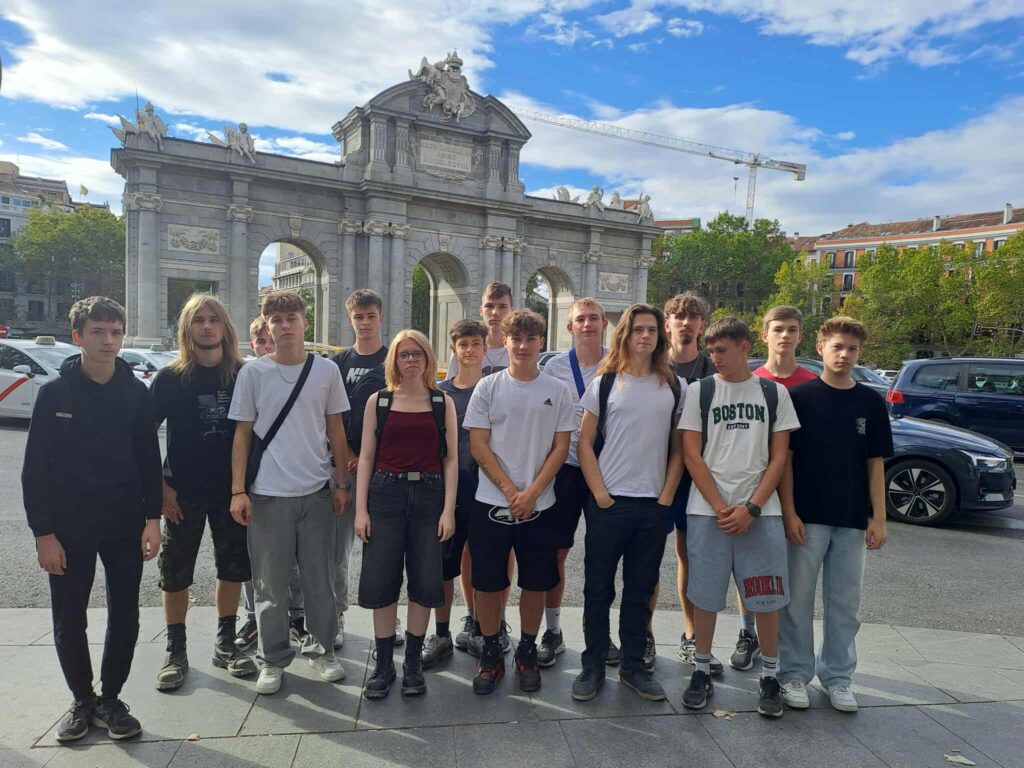 Osoby stojące przed bramą