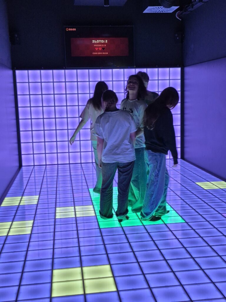 Grupa osób stojąca na kolorowej powierzchni