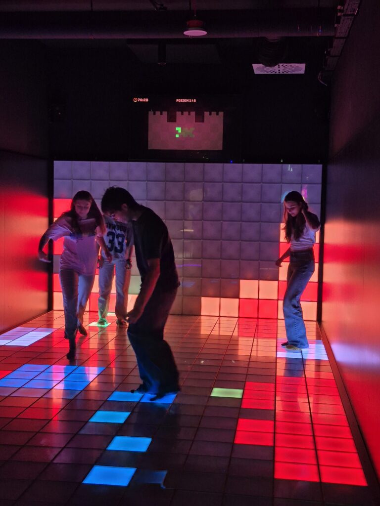 Grupa osób stojąca na kolorowej powierzchni