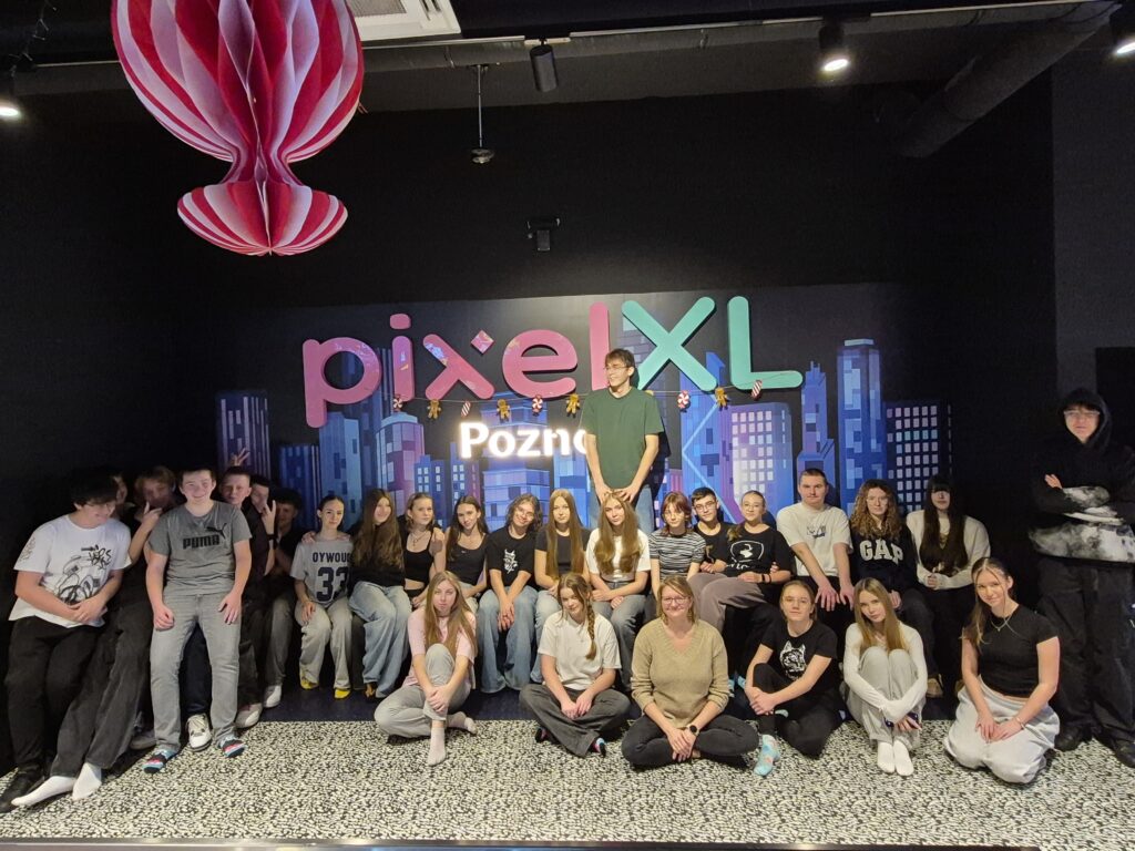 Grupa osób stojąca na kolorowym tle