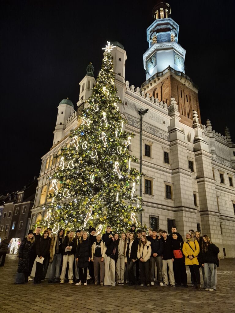 Grupa osób stojąca przy choince 