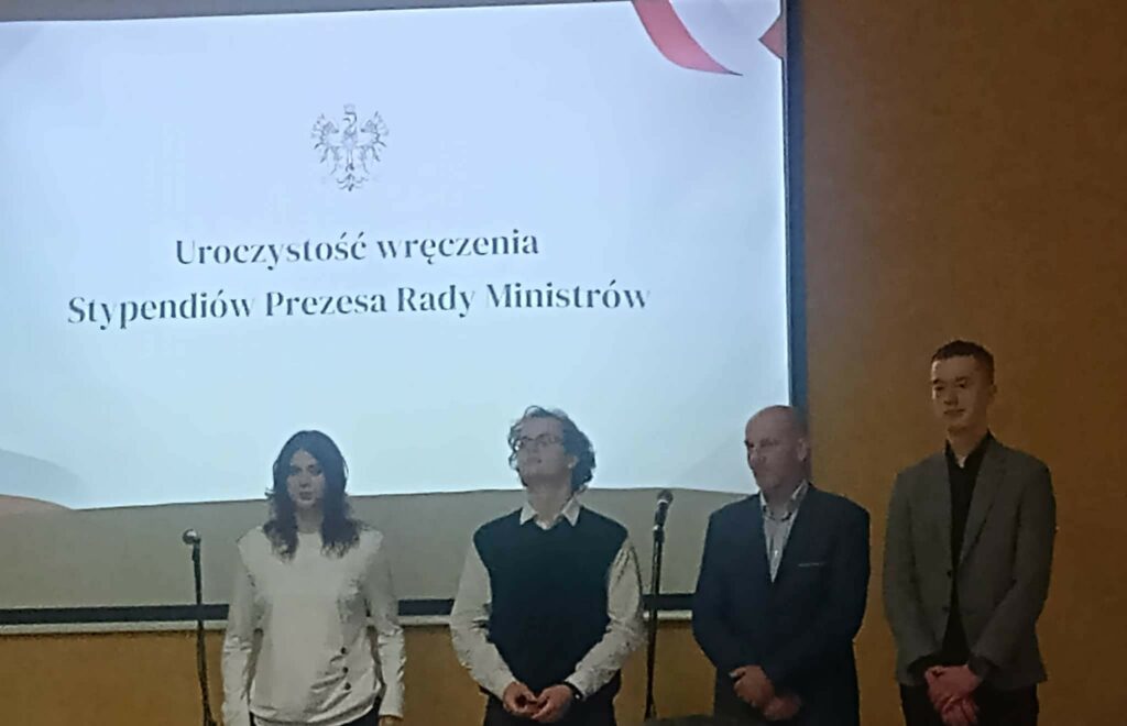 Grupa osób stojąca na scenie