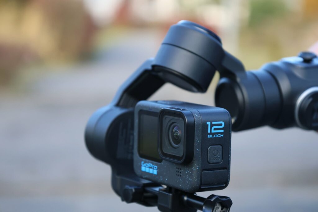 Kamera sportowa GoPro Hero 12 Black zamocowana na stabilizatorze ręcznym.