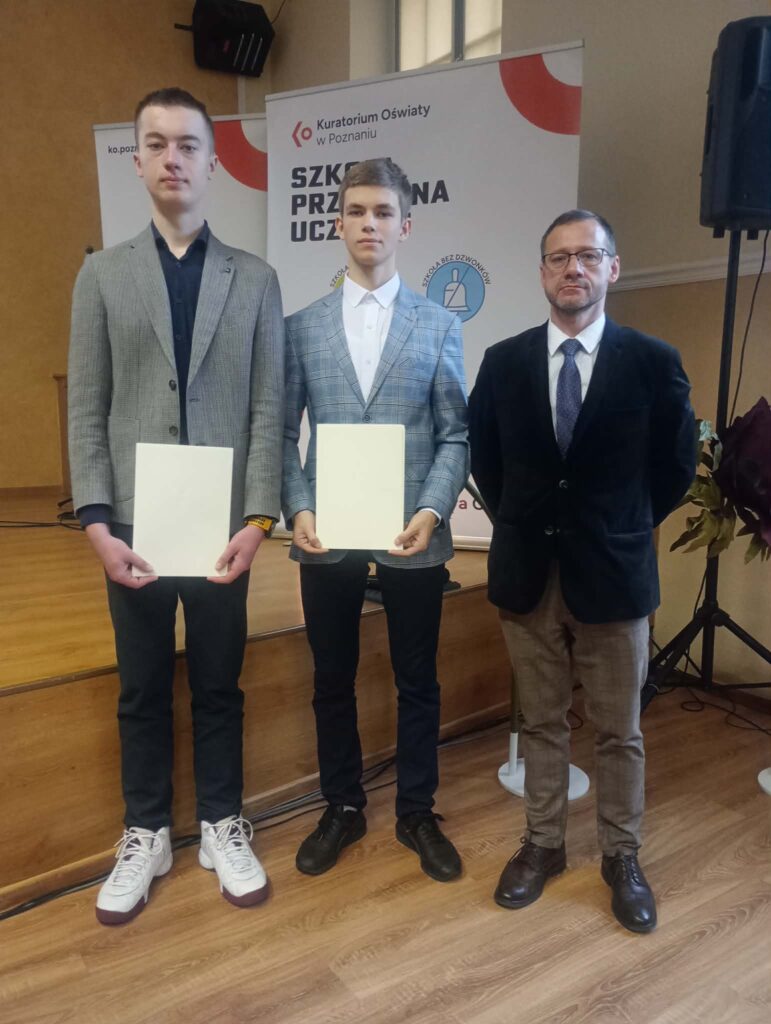 3 osoby stojące przy scenie