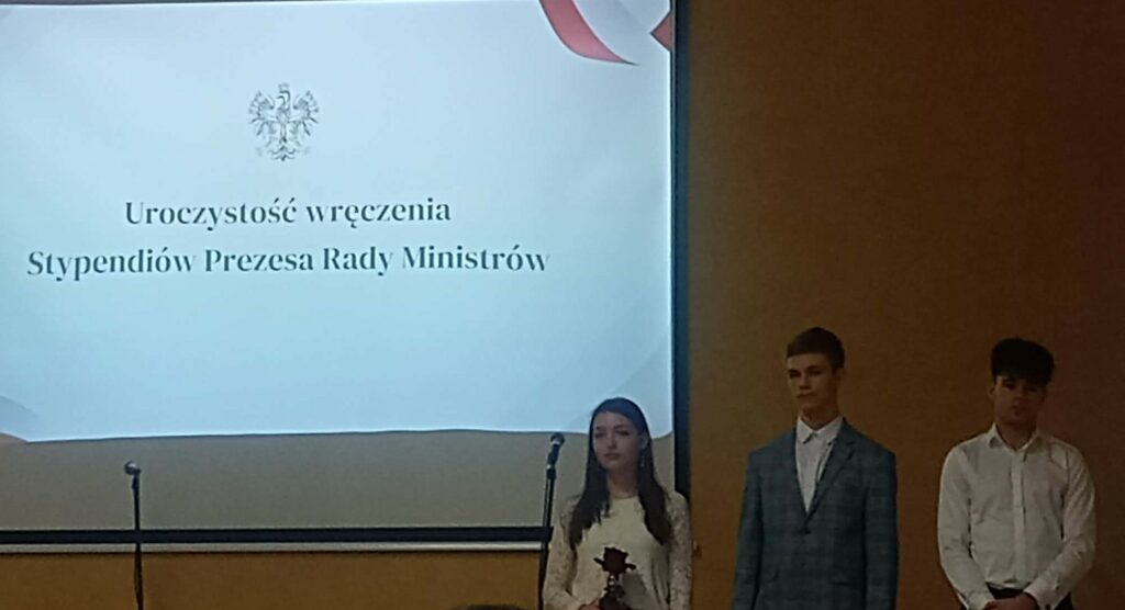 Grupa osób stojąca na scenie