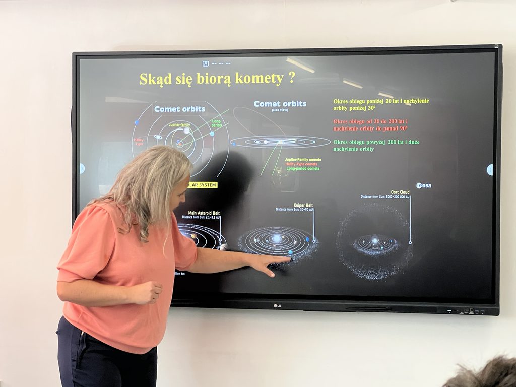 Schemat układu słonecznego z zaznaczonymi orbitami komet i objaśnieniami dotyczącymi okresów obiegu i nachylenia orbit.