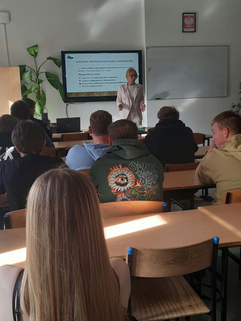 Kobieta prowadzi wykład o tym, jak znaleźć pracę, dla grupy młodzieży siedzącej w klasie.